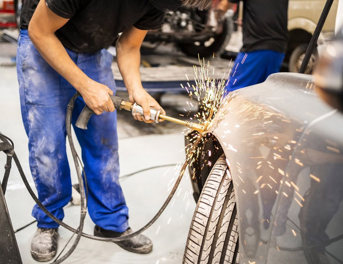 Using a spark welder to repair a dented fender.