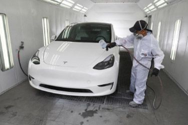 Paint repair - white car in a paint booth.