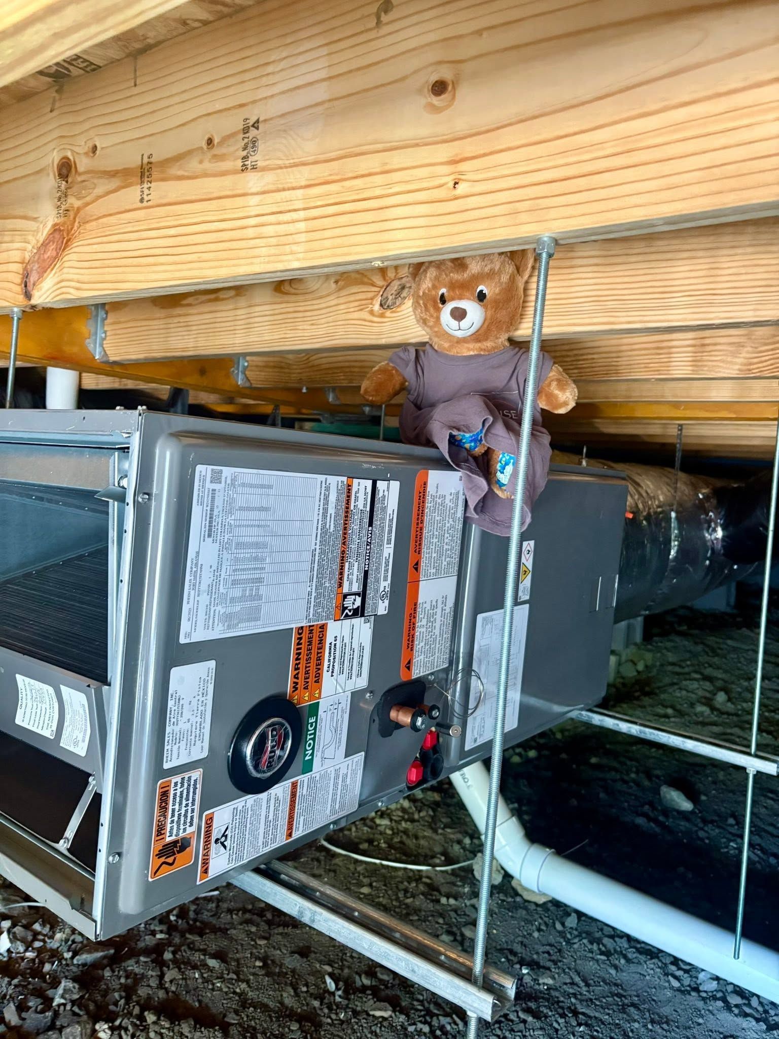 An air conditioner is sitting in the attic of a house under construction