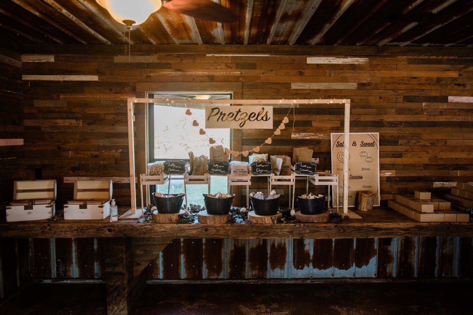 A rustic bar or food station with a wooden sign that reads 
