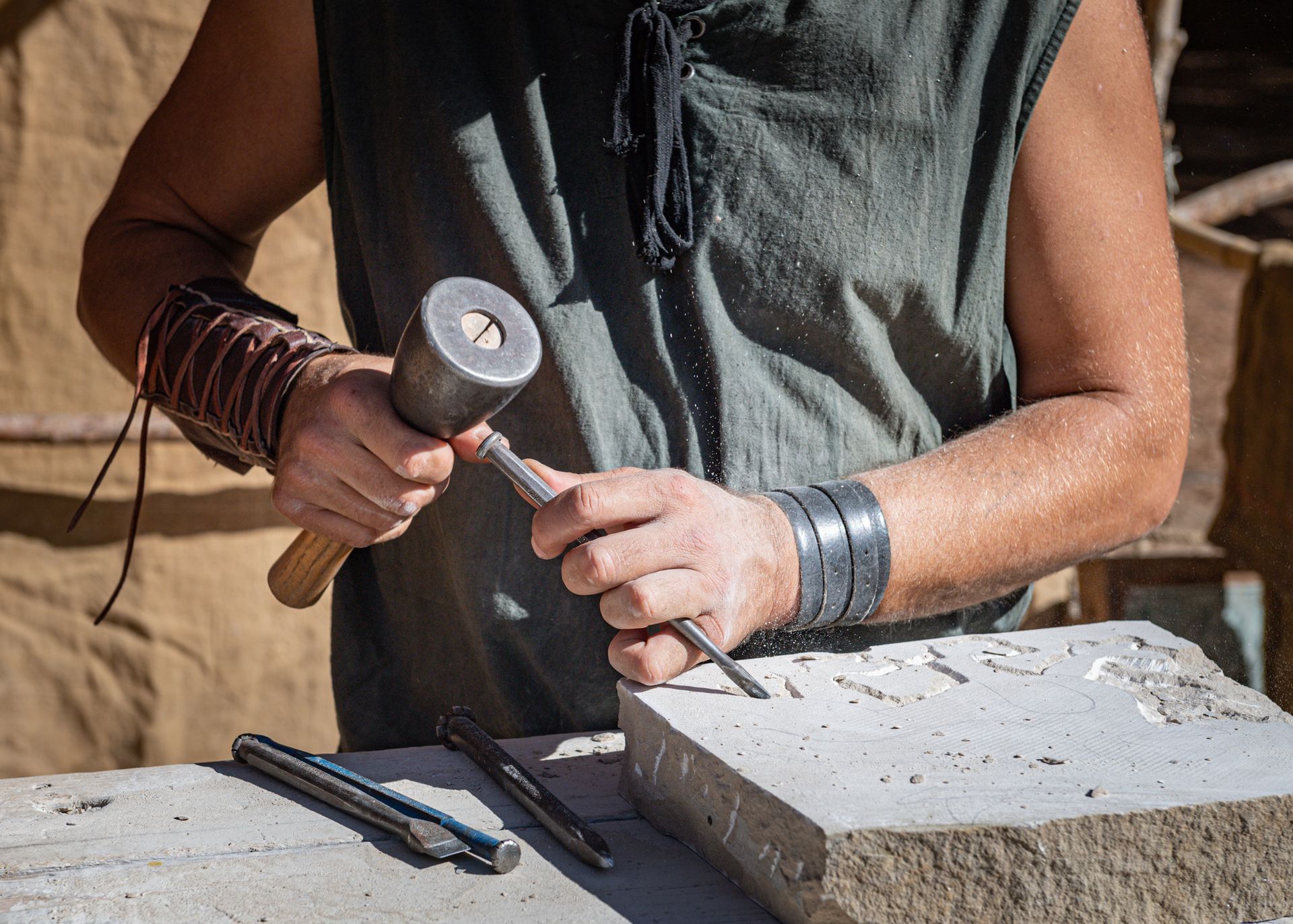 A man is carving a stone with a hammer and chisel – Colac, VIC - Bartlett Bros Pty Ltd