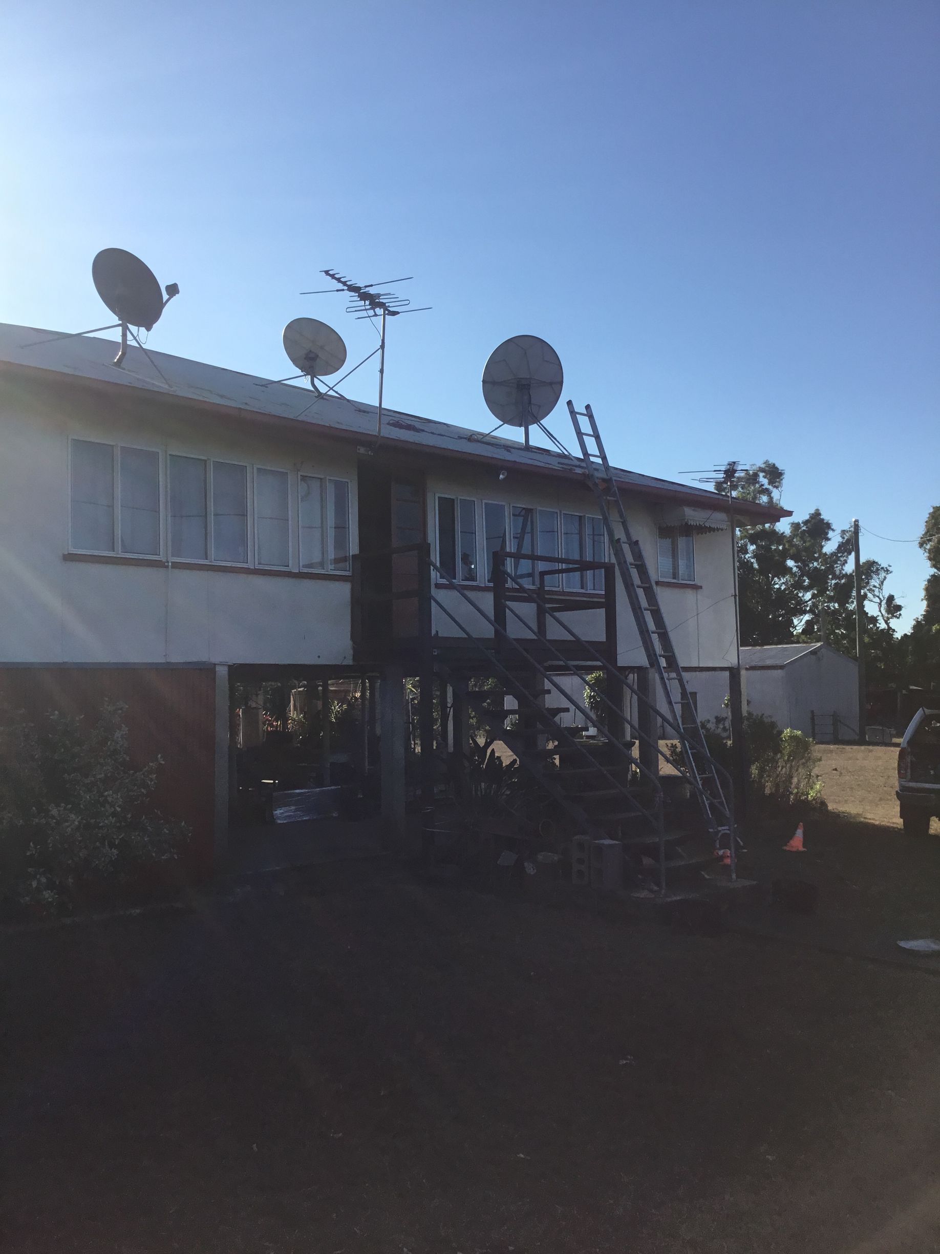 Two-story House With Multiple Satellite Dishes and a Ladder — Apex Antenna Solutions Pty Ltd in Bowen, QLD
