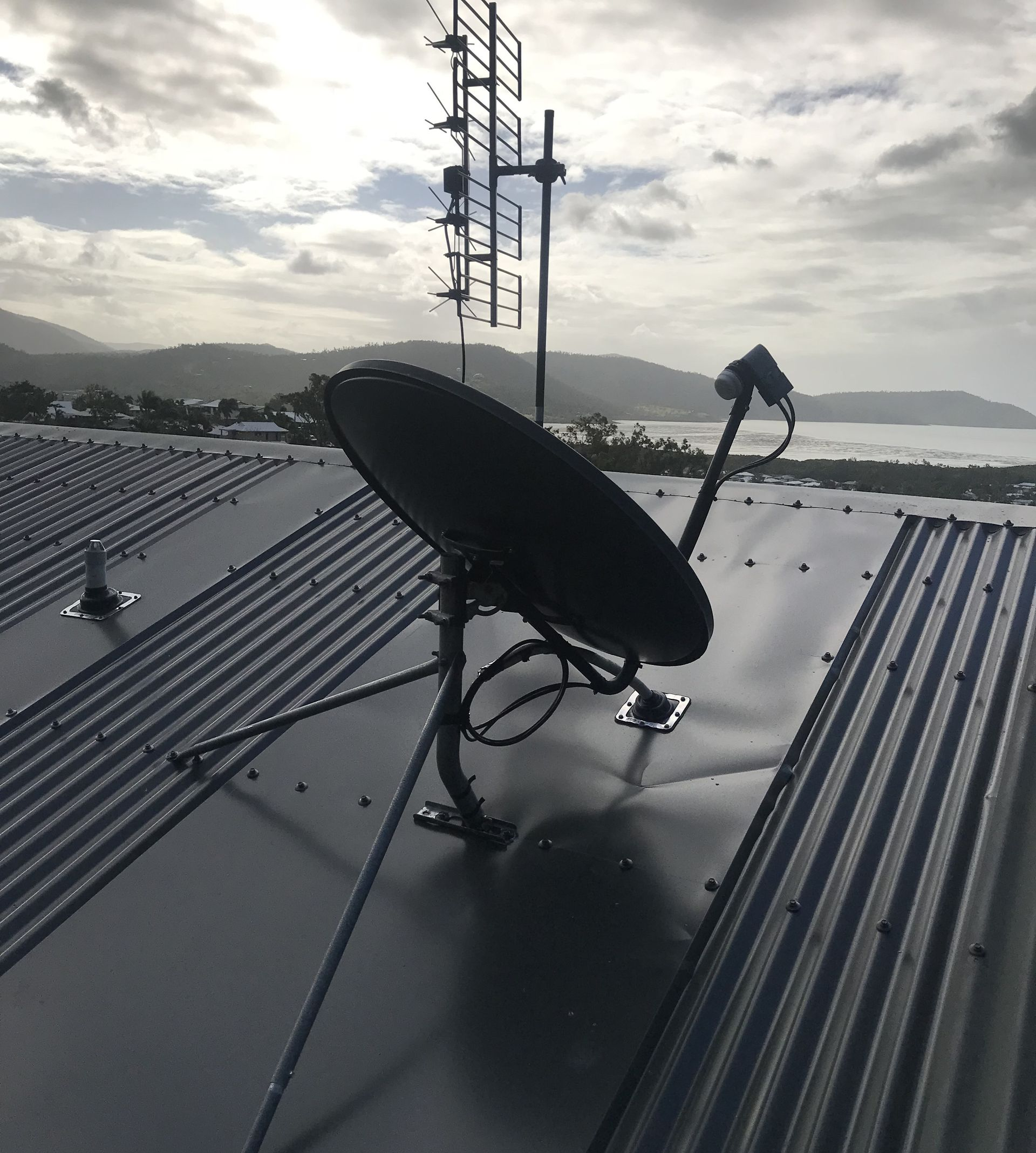 Person Fixing a Satellite Dish — Apex Antenna Solutions Pty Ltd in Whitsundays, QLD