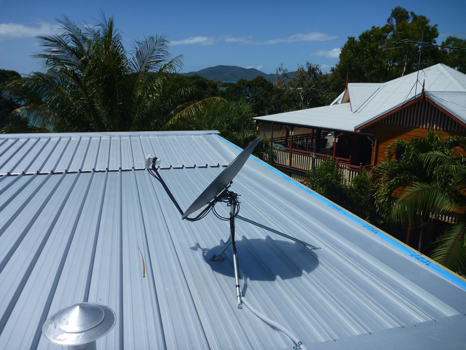 Technician on a Rooftop Installing a Satellite Dish — Apex Antenna Solutions Pty Ltd in Bloomsbury, QLD