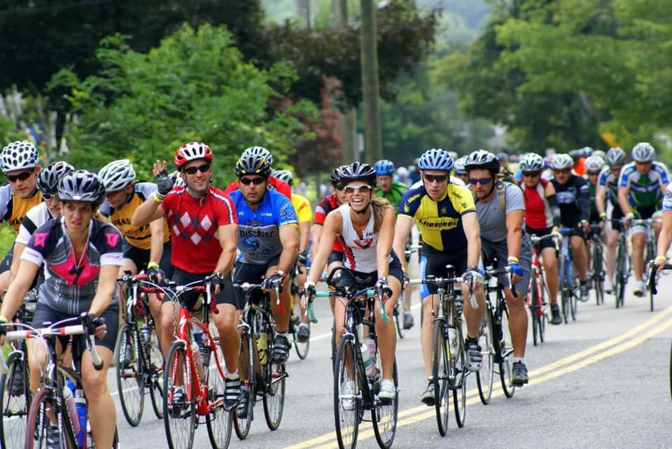 A group of people are riding bicycles down a road