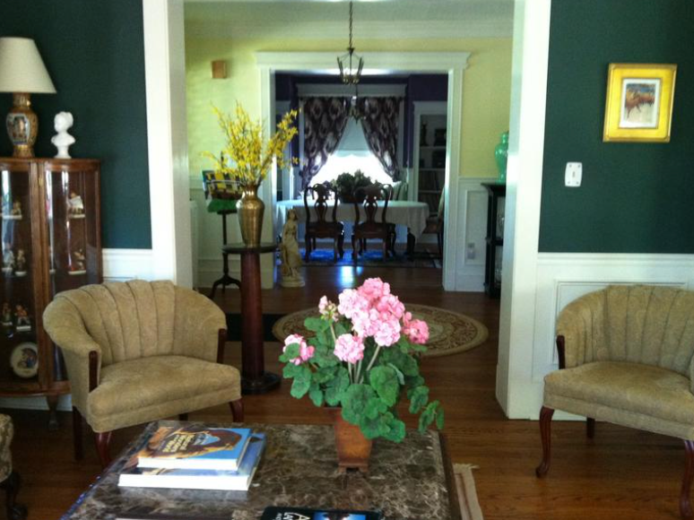 A living room with a vase of pink flowers on the coffee table