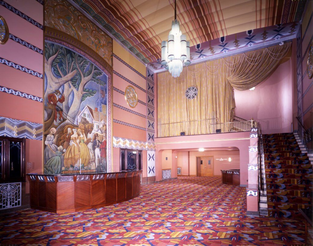 A large room with a painting on the wall and stairs