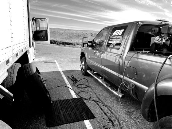 A black and white photo of a truck parked next to a trailer.