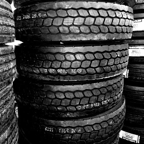 A black and white photo of a pile of tires stacked on top of each other.