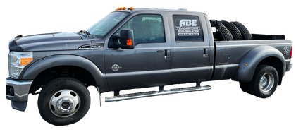 A gray pickup truck with tires in the bed on a white background.