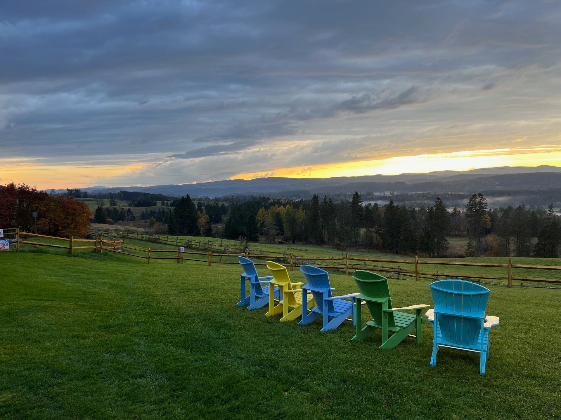 Fall sunset over the Wildflower Inn lawn with Adirondack chairs facing west across the valley, Lyndonville, Vermont