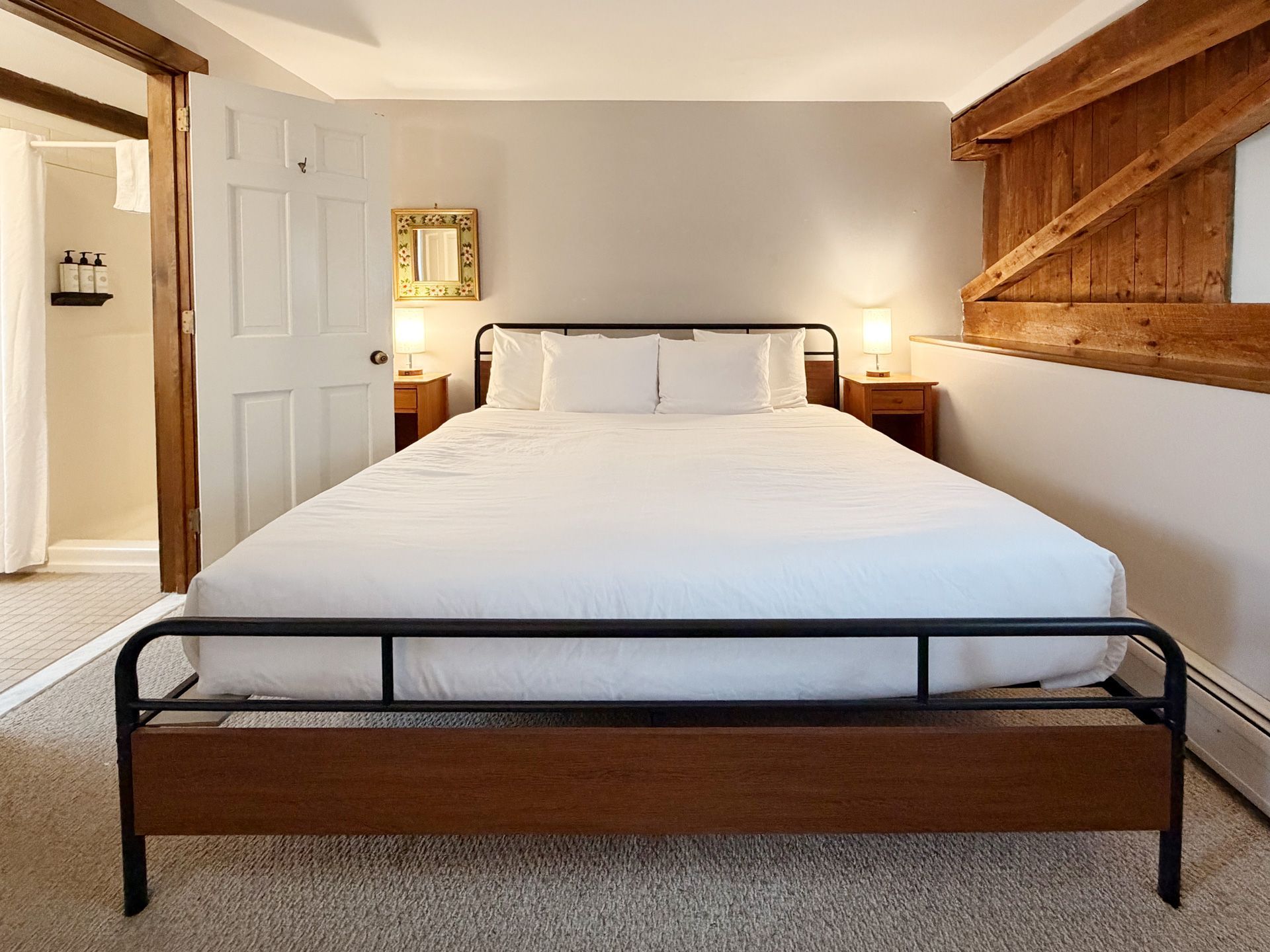 Bright bedroom with a bed, white bedding, wooden furniture, and a window seat nook