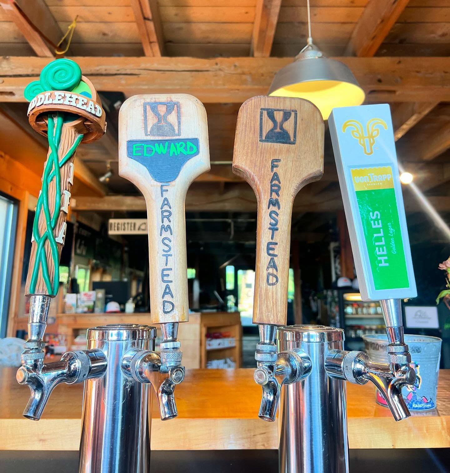 Beer tap handles labeled Edwards, Forest Head, and Helles in a rustic bar interior