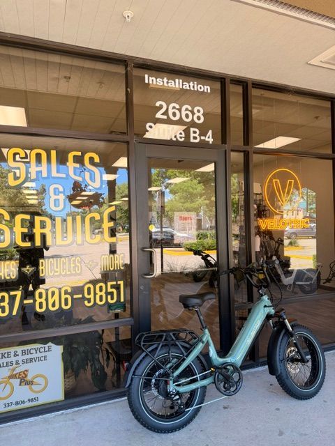 Electric bike parked outside a service shop with “Sales & Service” window signage