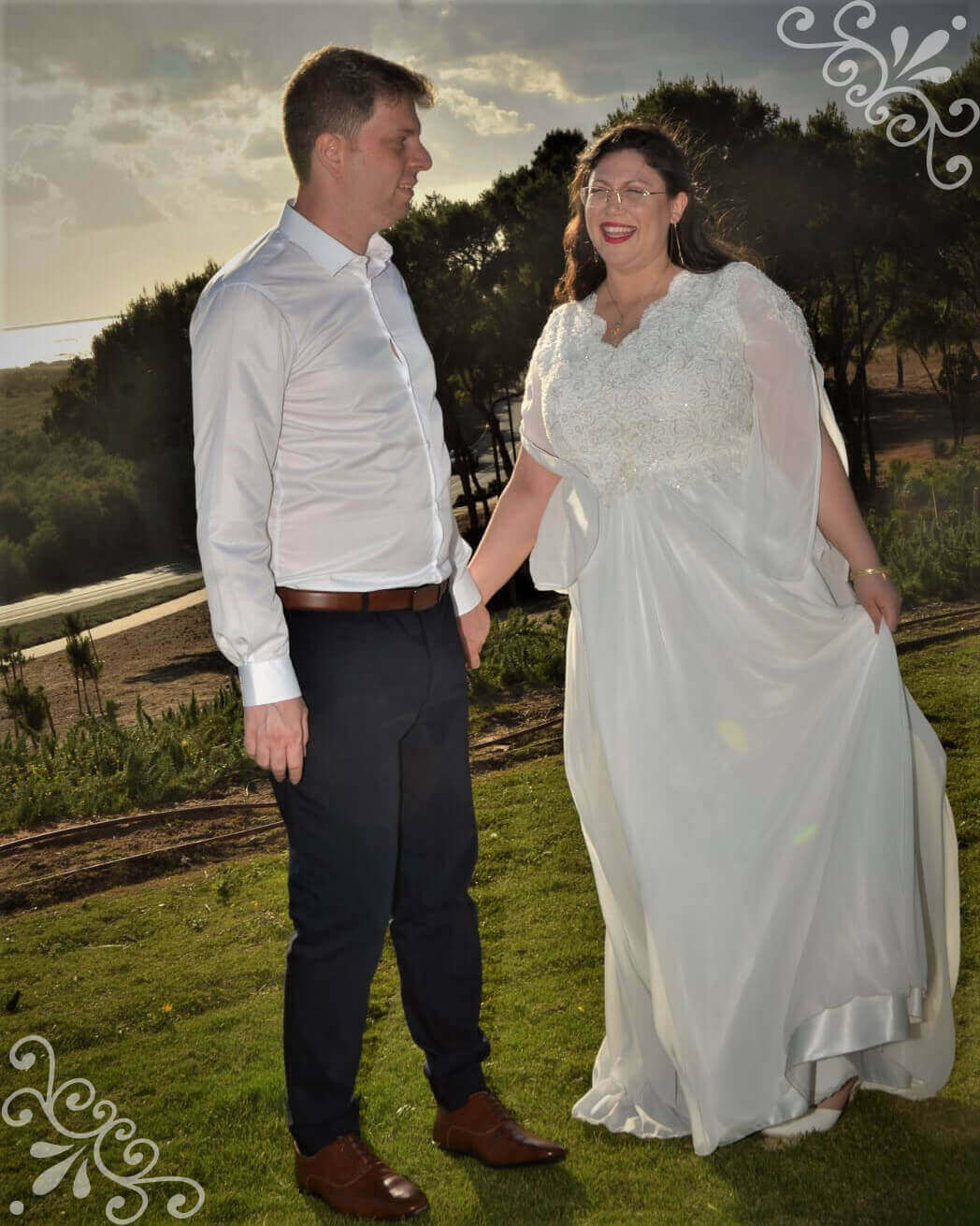 זוג בלבוש רשמי, האישה בשמלת כלה, אוחזים ידיים בחוץ.
