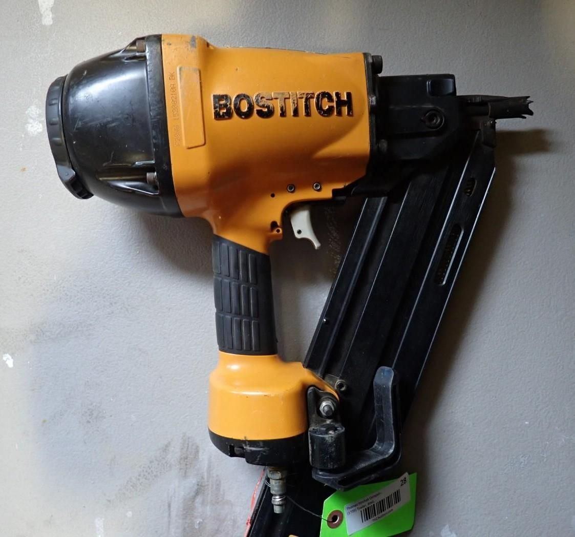 A yellow Bostitch framing nailer with a black magazine and handle against a neutral background.
