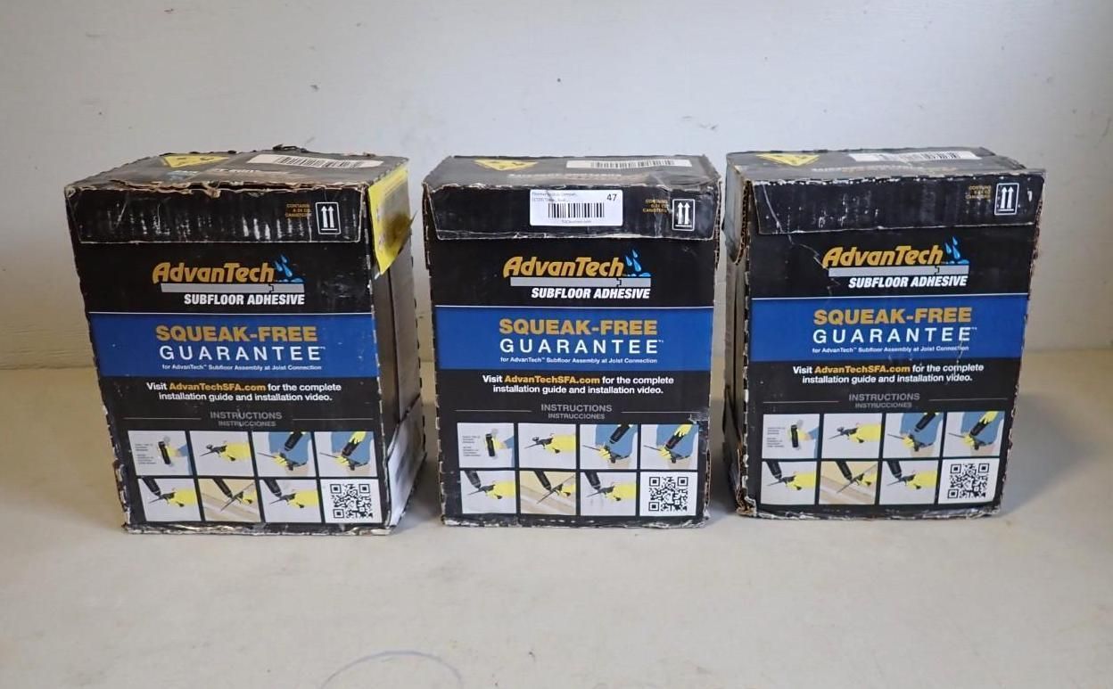Three AdvanTech subfloor adhesive boxes, featuring a blue and black design, lined up against a plain white wall.