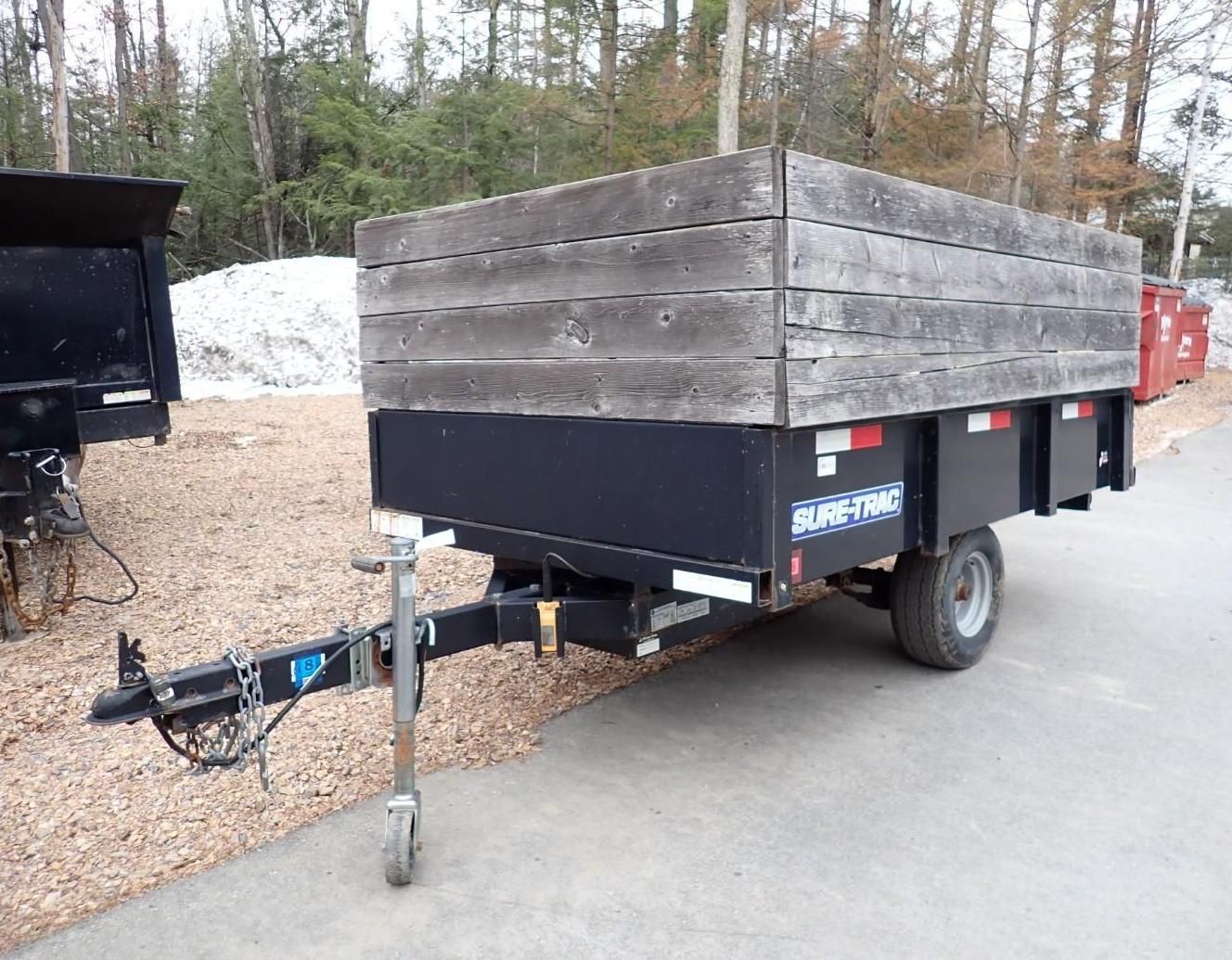 A Sun-Trac dump trailer with wooden side extensions.
