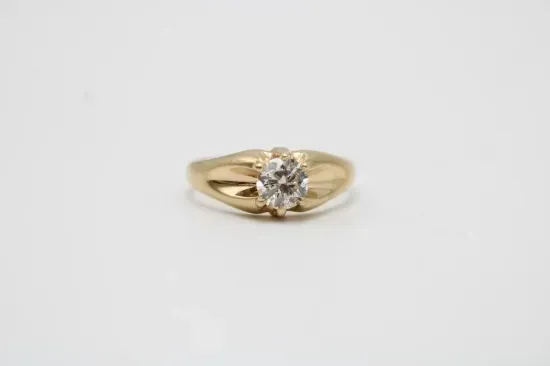 Gold ring with a large diamond on a white background.
