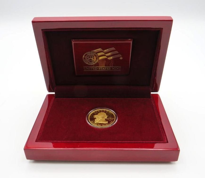 Gold coin in a red velvet-lined box with gold emblem on the inside lid.