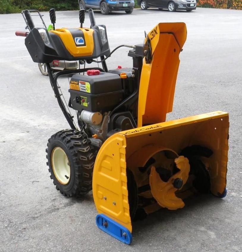 Yellow and black Cub Cadet 3X snowblower, outdoors on pavement.