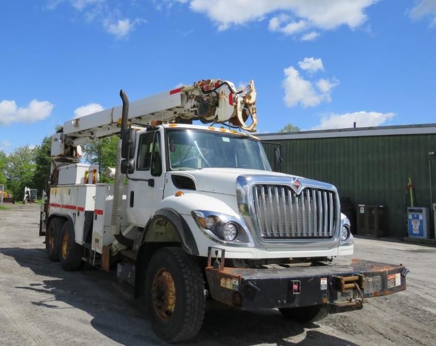 White International utility truck with a crane parked outdoors.