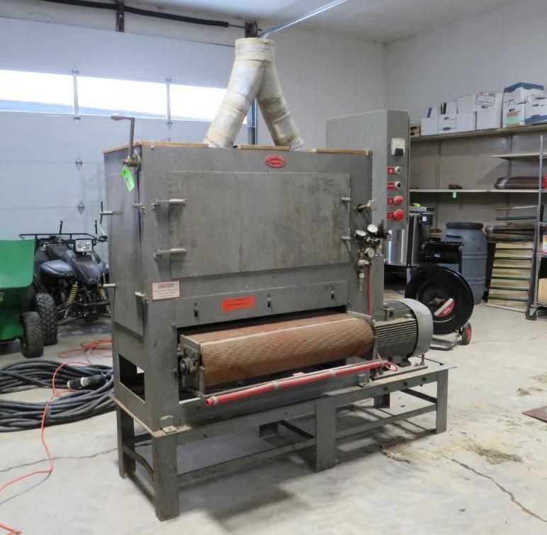 Large industrial drum sander machine in a workshop.
