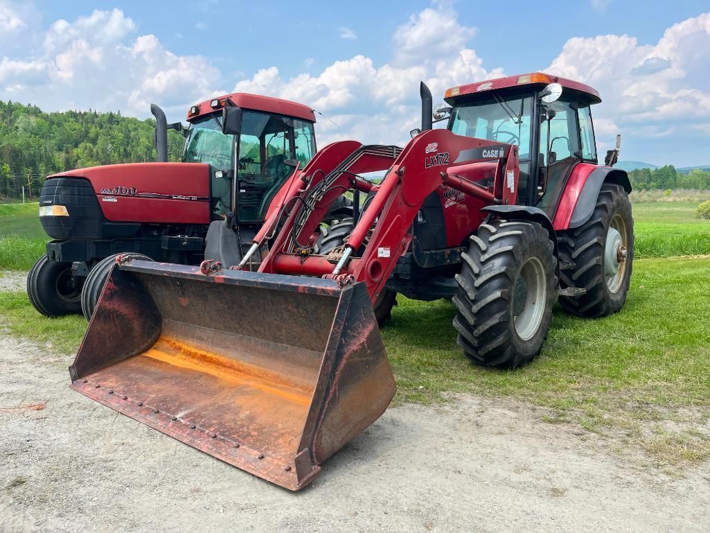 Two red Case IH tractors with a front-end loader in a field.