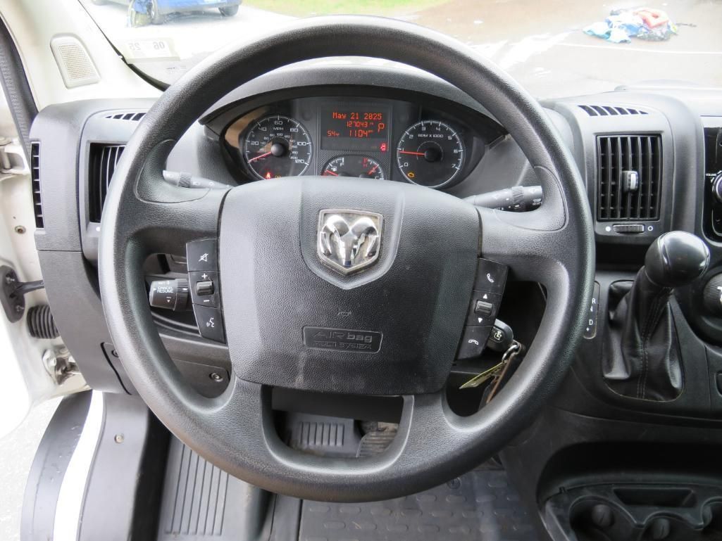 Black steering wheel of a Dodge Ram truck, dashboard gauges visible, interior shot.