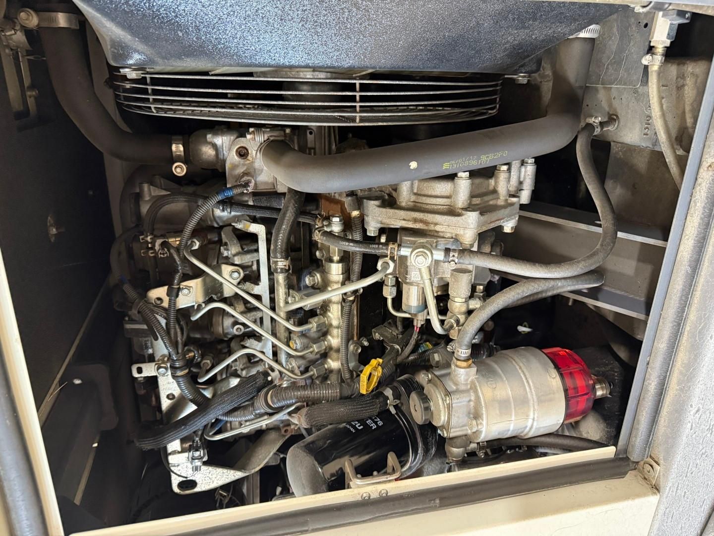 Diesel engine with various tubes and components inside an enclosed space.