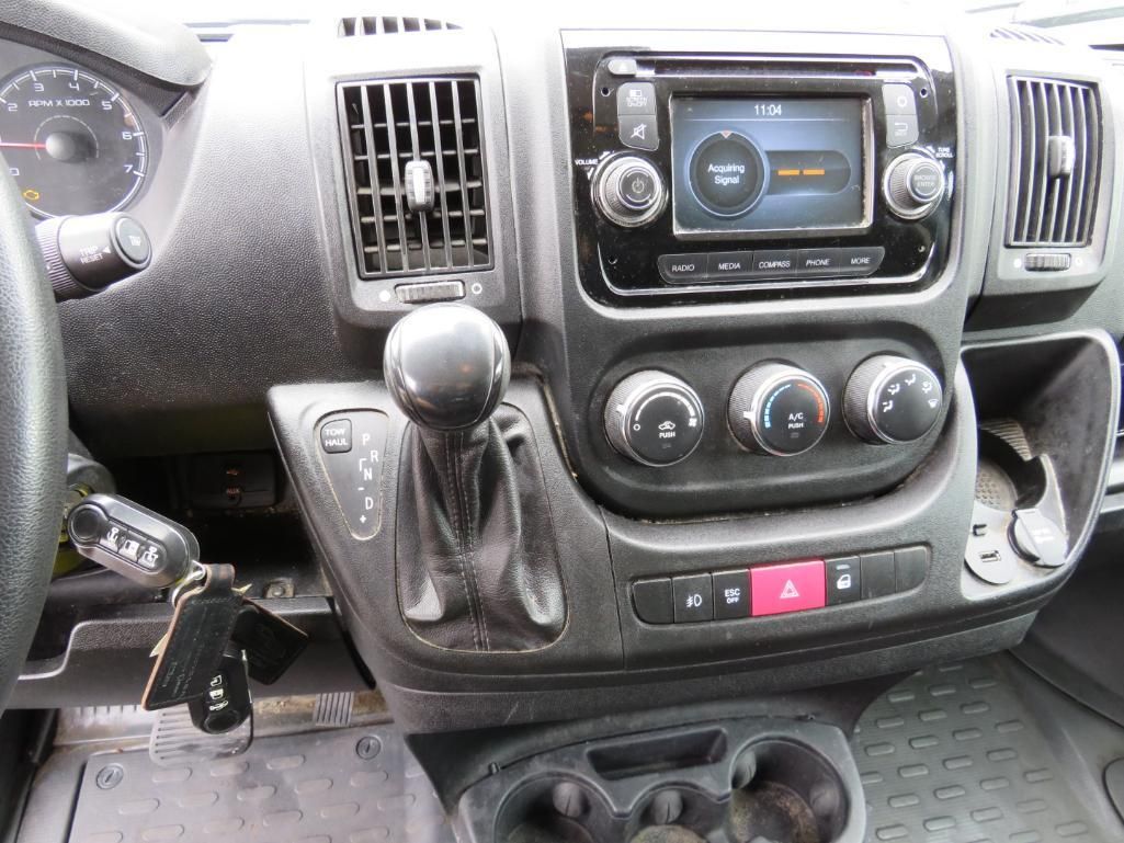 Interior view of a vehicle dashboard with the gearshift, radio, vents, and climate control dials visible.