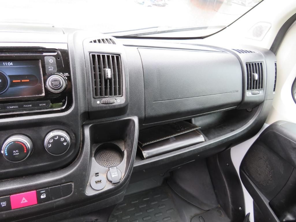 Black vehicle dashboard with radio, vents, cup holder, and storage compartment.