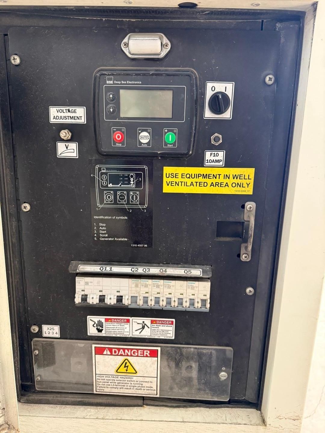 Black electrical control panel with various gauges, switches, and circuit breakers.