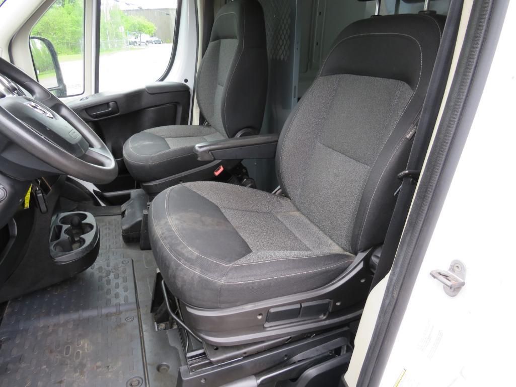 Interior view of a white van with black seats, a steering wheel, and a cup holder.