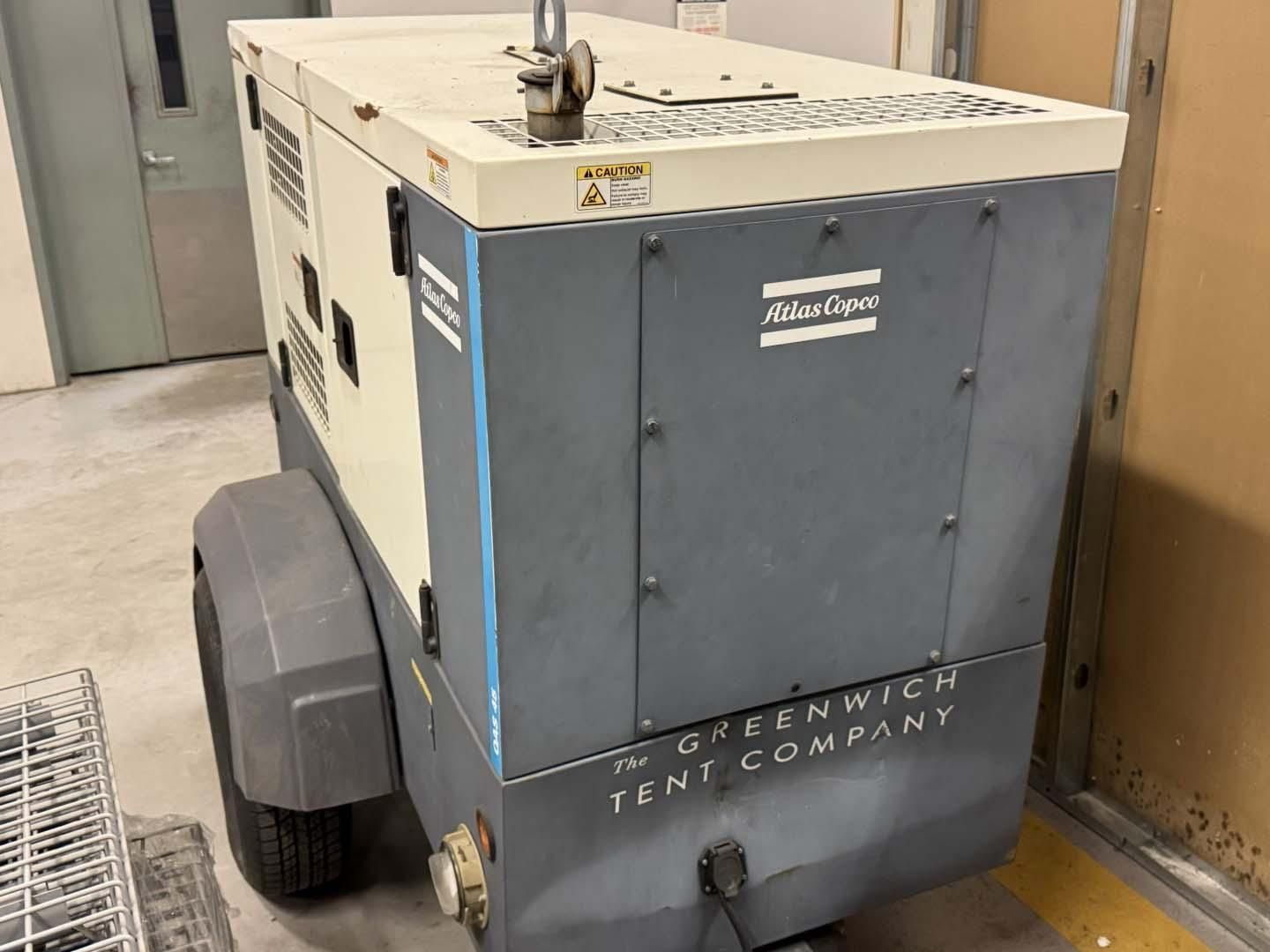 Gray and cream-colored Atlas Copco air compressor on wheels.