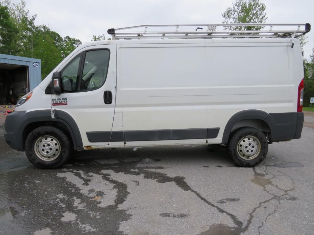 White work van with ladder rack parked outside.