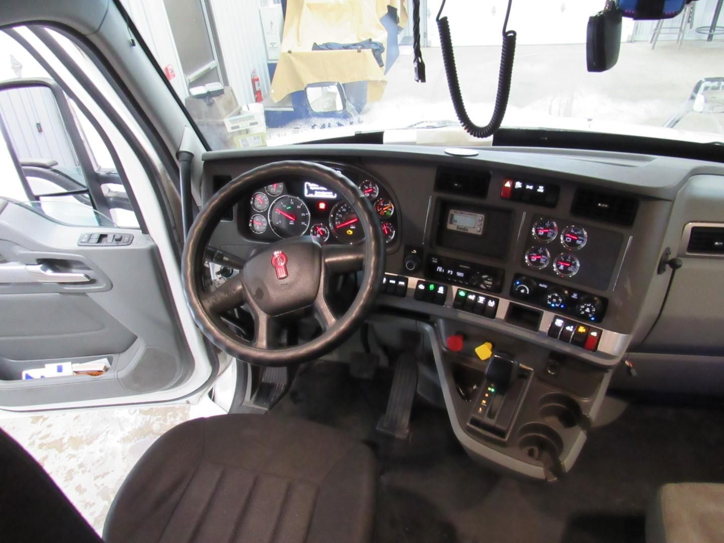 Interior view of a truck cab, showing the steering wheel, dashboard, and various controls.