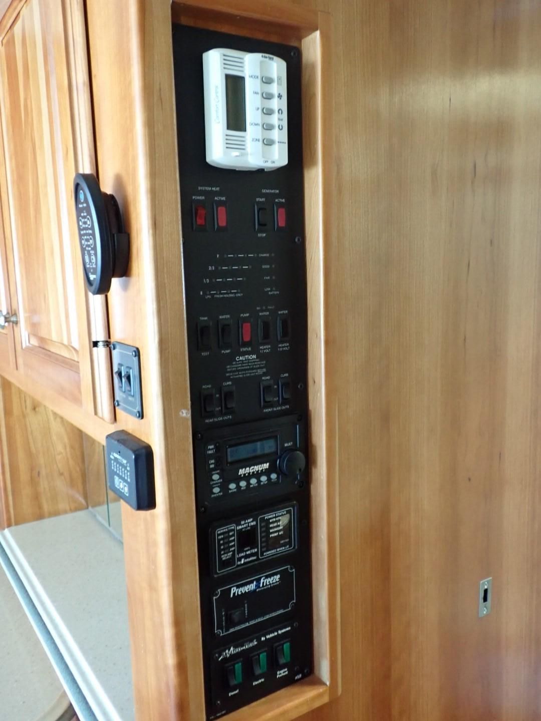 Control panel inside wooden cabinet with buttons, switches, and a thermostat.