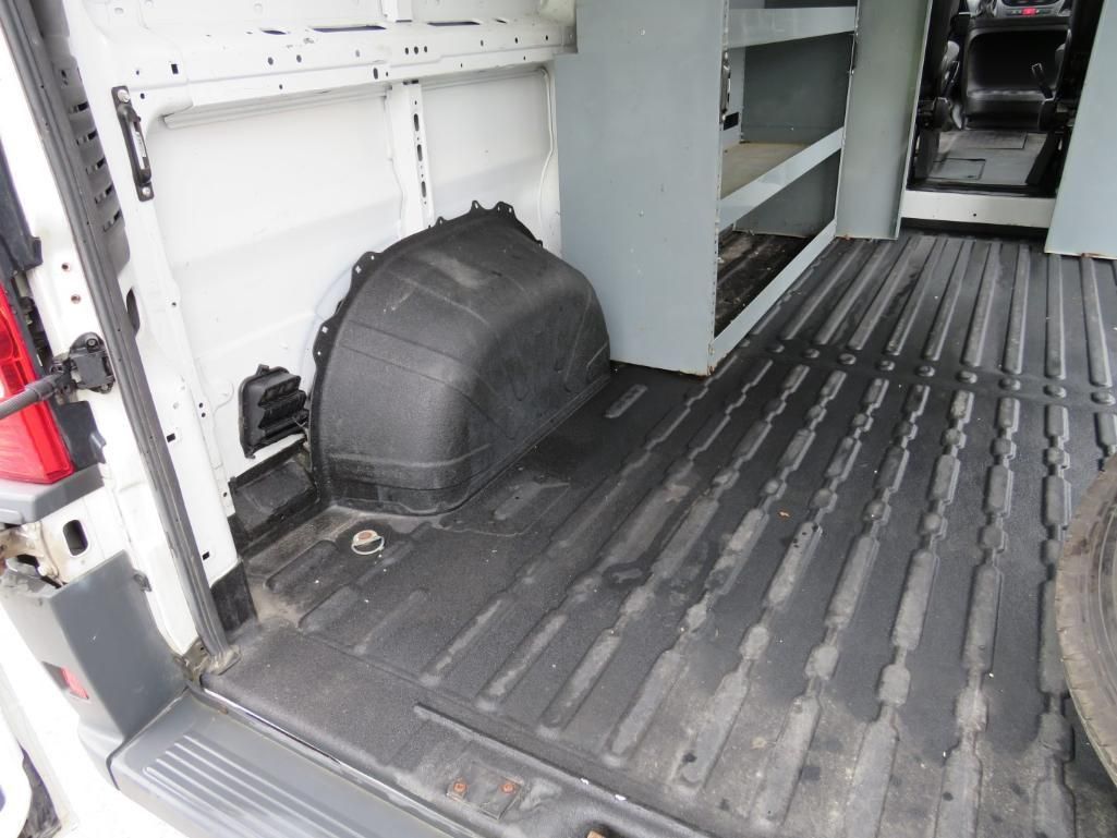 Interior of a white van cargo area. Black rubber floor, shelves on right, a wheel well on the left.