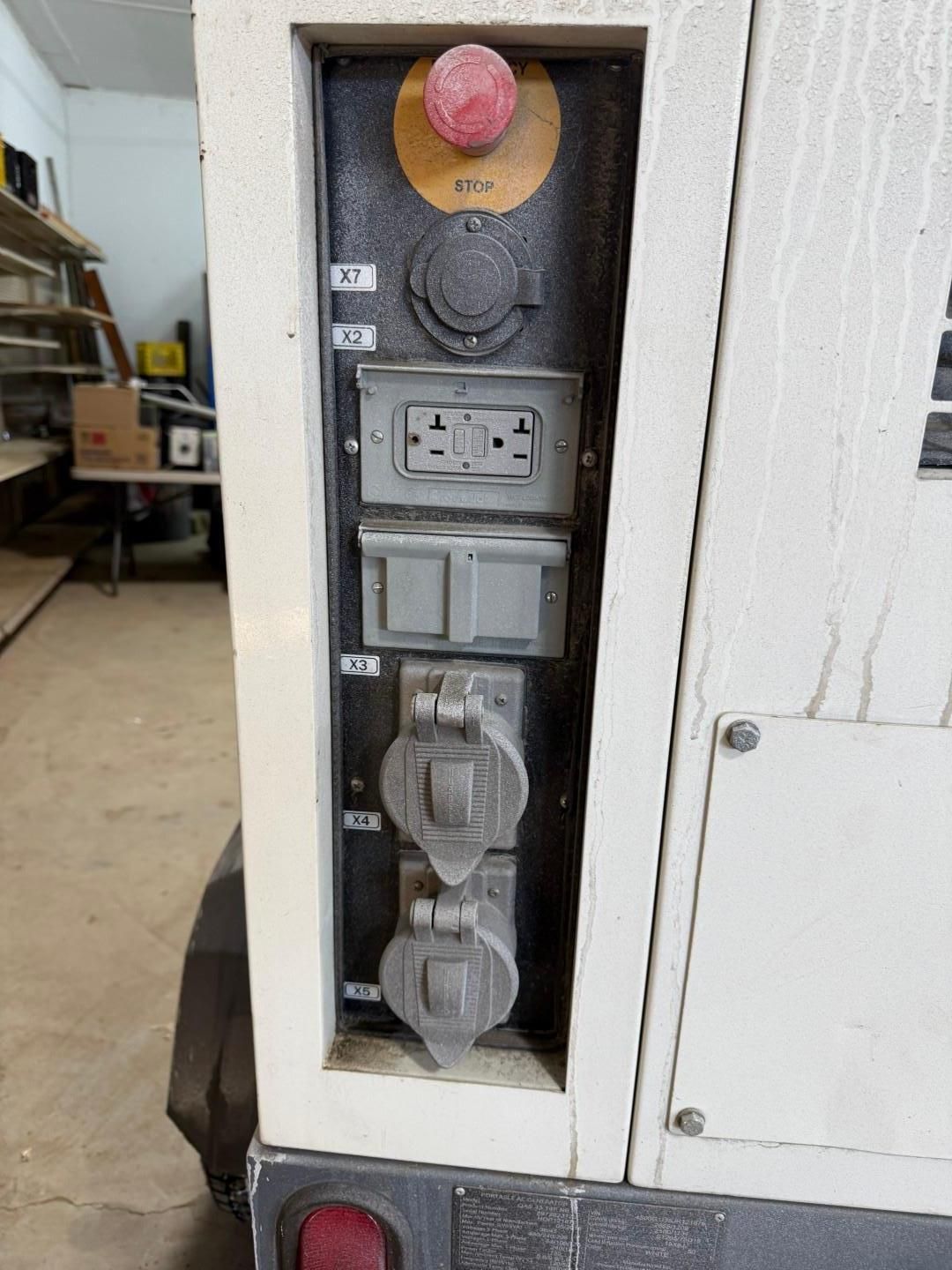 Panel with various electrical outlets and a red emergency stop button.