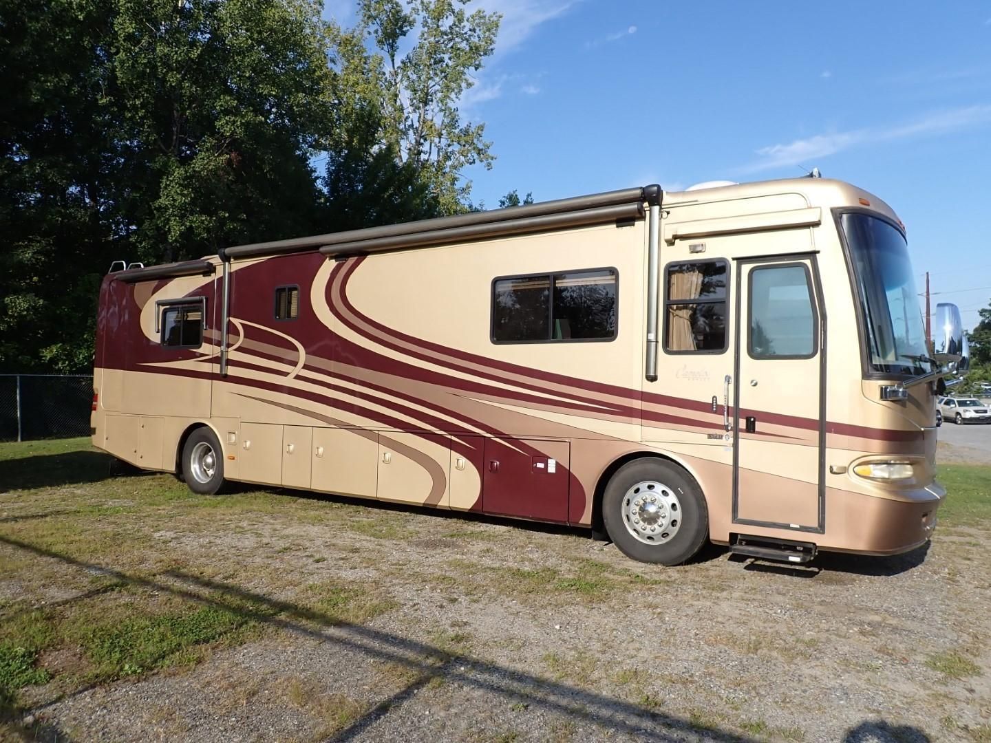 Large beige and burgundy recreational vehicle parked outdoors on a sunny day.