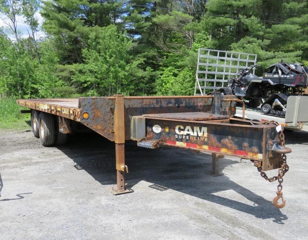CAM flatbed trailer outdoors on a sunny day.