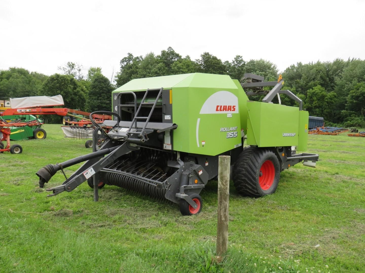 Green Claas baler in a grassy field.