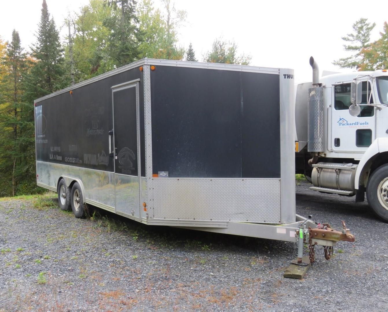 Enclosed black and silver trailer parked outdoors.