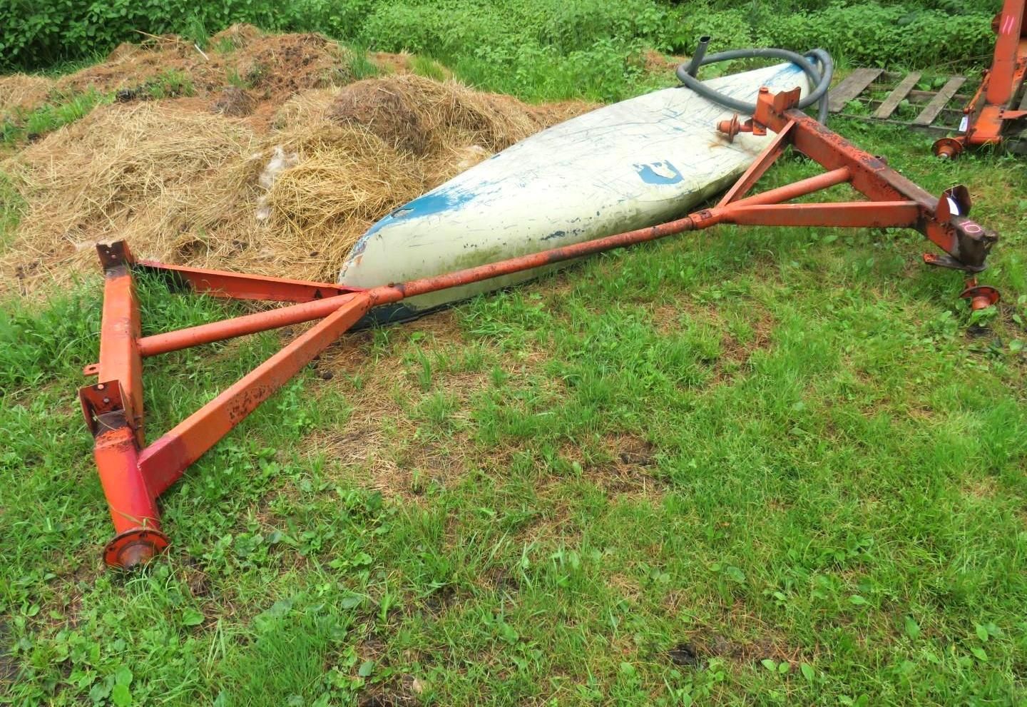 Orange metal agricultural equipment on grass.