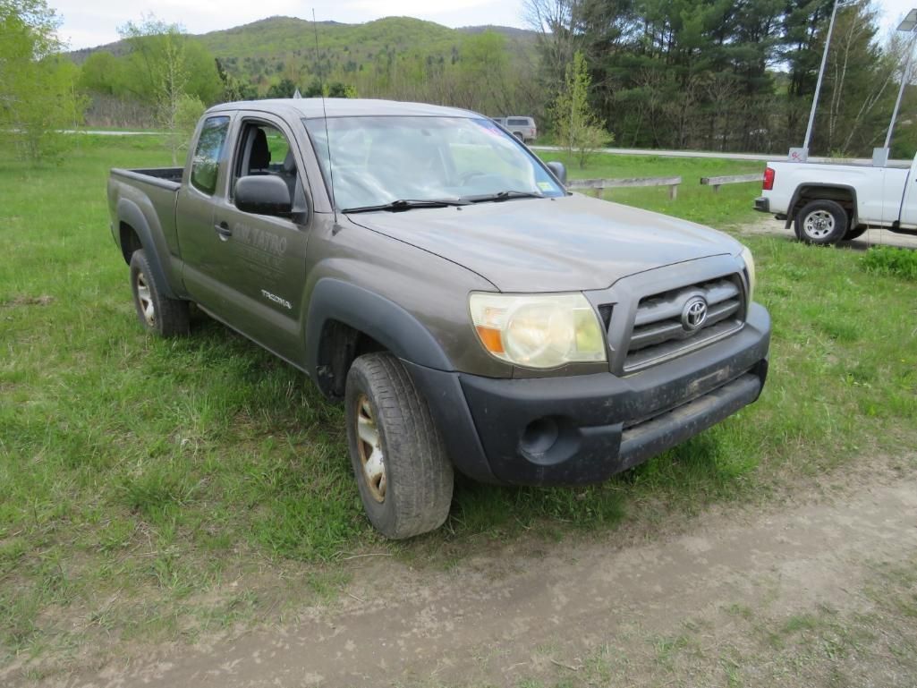 Brown Toyota Tacoma pickup truck parked on grass.