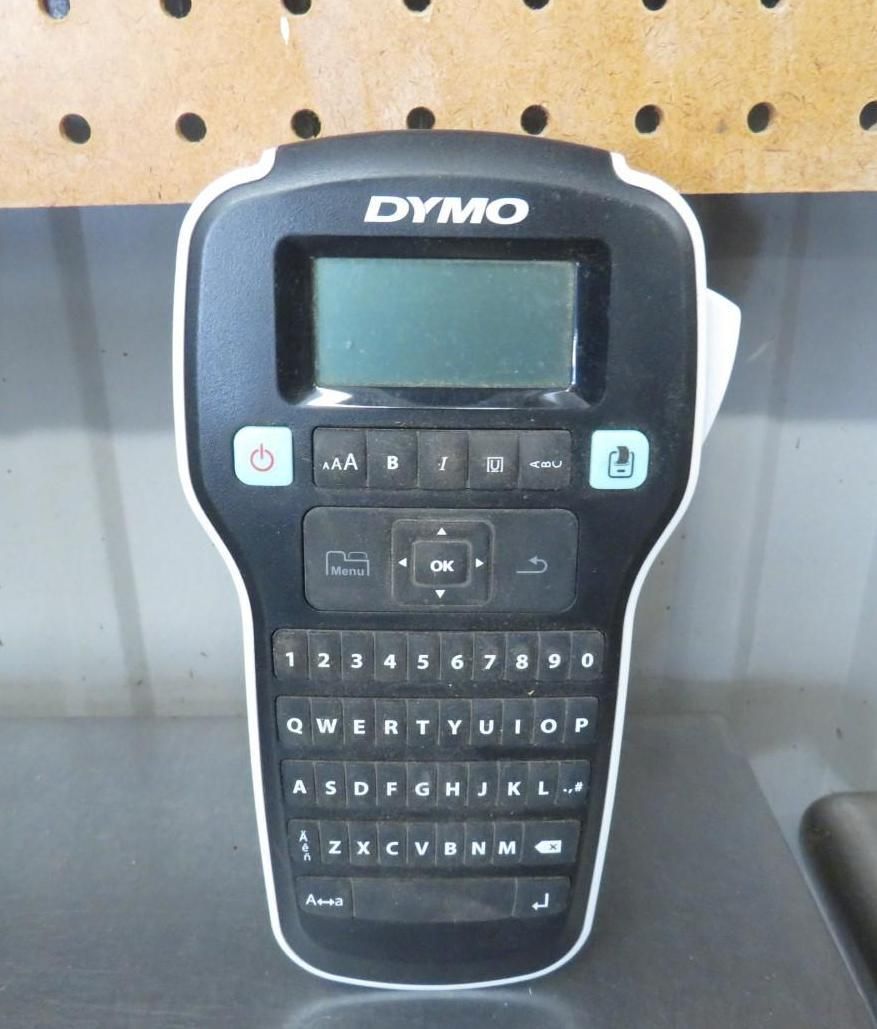 Black and white DYMO label maker on a metal surface.
