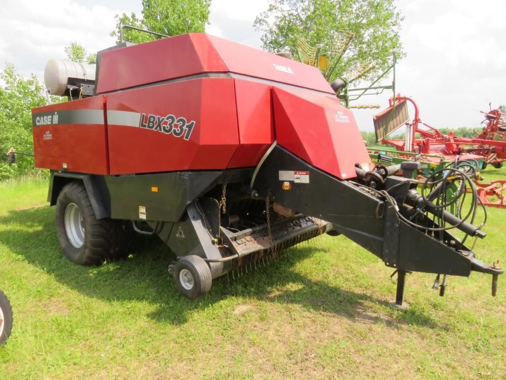 Red Case IH Ver-21 large round hay baler in a grassy field.