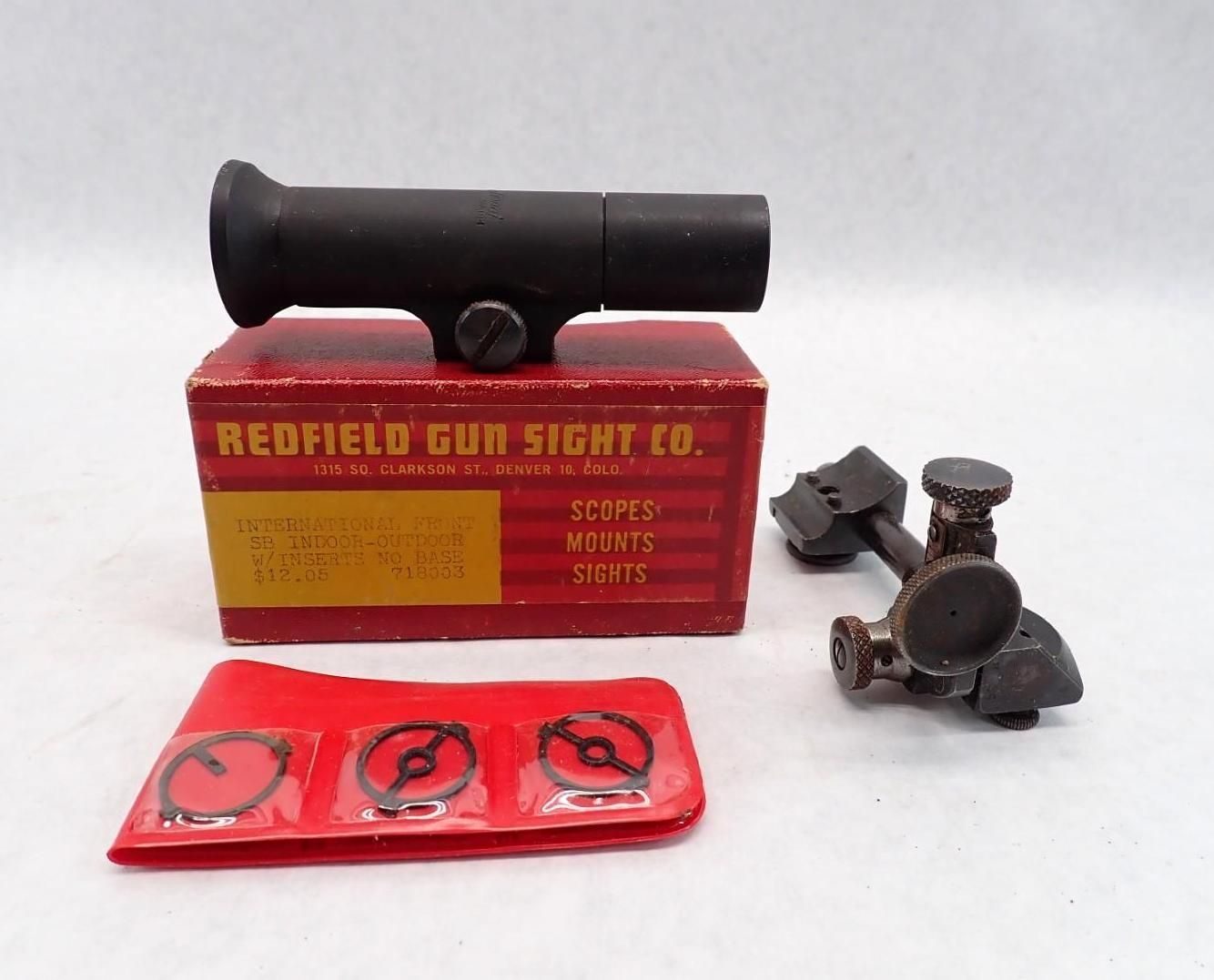 Redfield gun scope set with box, mounts, and rings on a white surface.
