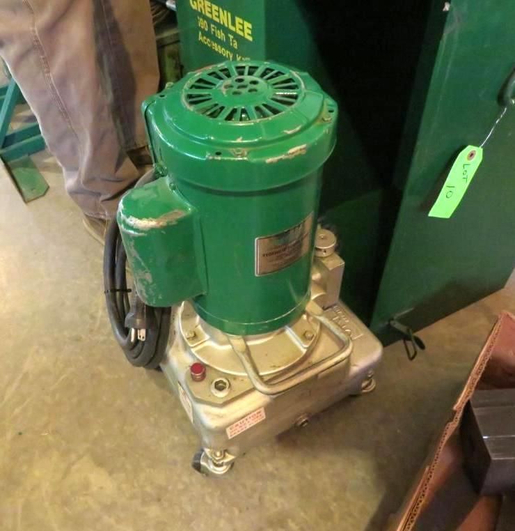 Green electric pump with green motor housing and silver base on wheels.